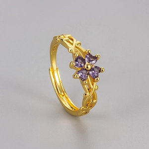 Vintage gold vine ring with purple zircon clover detail on a minimalist grey background