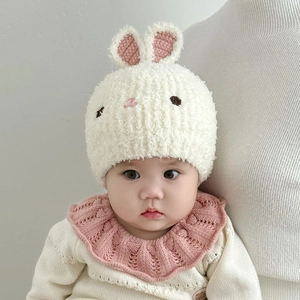 Detaillierte Textur der weißen Baby-Strickmütze Hase und des rosa Rüschenkragens