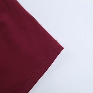 Détail de la robe bordeaux montrant la couture à double aiguille de haute qualité
