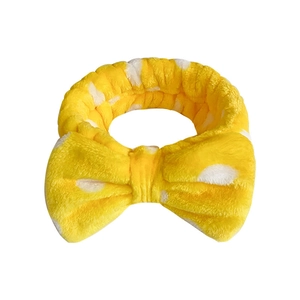 Yellow coral fleece headband with white polka dots and a large bow for spa and washing