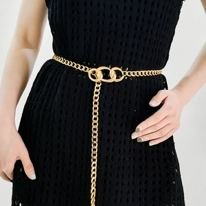 Elegant gold metal chain belt with tassel detail styled on a black dress for women