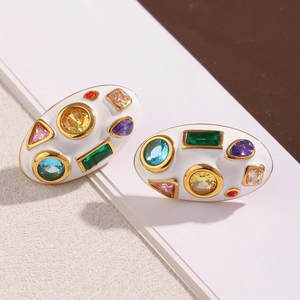Détail de boucles d'oreilles ovales plaquées or 18K avec émail blanc et cristaux colorés
