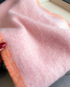 Close-up of pink and orange color-block scarf showing soft plush texture and fabric detail