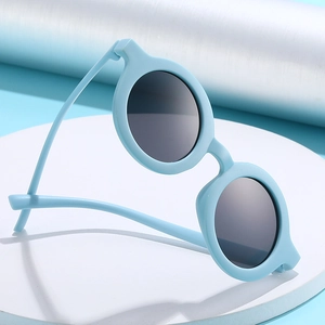 Kids round matte sky blue sunglasses with dark grey UV protective lenses on display
