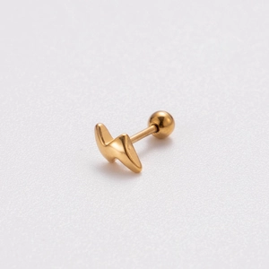 Macro detail of lightning bolt earring with a screw ball back in gold stainless steel