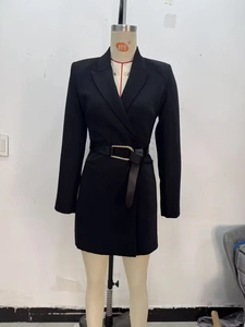 Dettaglio dell'abito blazer nero a doppio petto con cintura e fibbia dorata