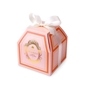 Pink hexagonal paper gift box with white ribbon bow and gold foil typography detail