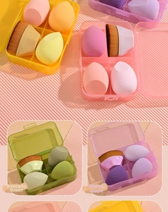 Detail of multi-color makeup sponges and foundation brush in a transparent storage box
