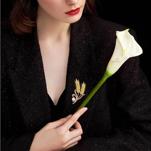 Elegant gold crystal wheat brooch with white pearl on a black tweed blazer outfit