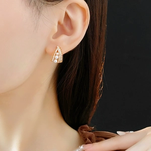 Macro detail of gold-plated earrings with pearls and pavé set cubic zirconia