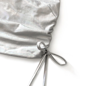 Gros plan sur le tissu argenté métallisé avec cordon latéral et plis texturés