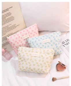 Detailed view of floral lace makeup bags in pink, blue, and yellow with embroidery