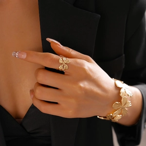 Detail of golden hollow petal bangle and ring set with textured finish on model