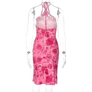 Back view of pink floral halter dress featuring backless design on white background