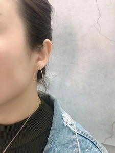 Close-up of classic large golden hoop earrings worn by a model for size and style reference