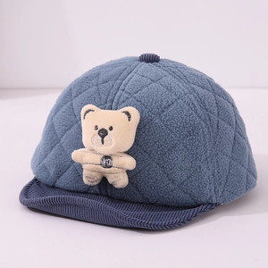 Detailed blue quilted baby hat with plush bear doll and corduroy brim for winter warmth