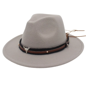 Detail of grey felt hat featuring decorative leather band and silver bull head emblem