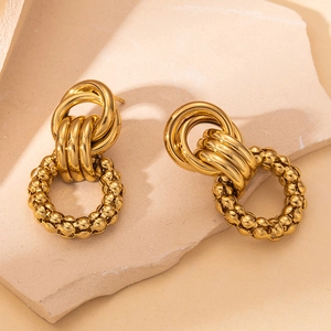 Detailed macro shot of vintage gold intertwined rings with beaded metal circular pendants