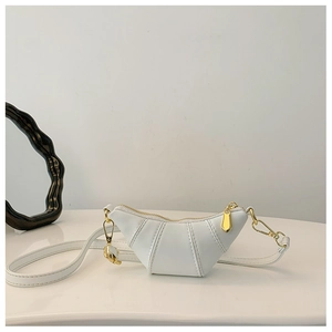 Close-up of white croissant-shaped crossbody bag with gold-tone zipper hardware