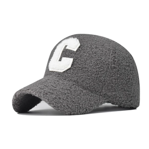 Close-up of the thick grey faux lamb wool texture and white C letter embroidery on cap