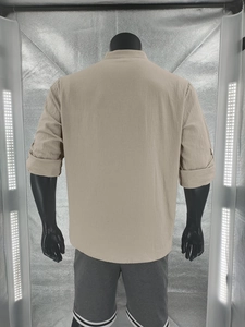 Rear view of a beige men's cotton linen shirt on a mannequin with roll-up sleeve detail