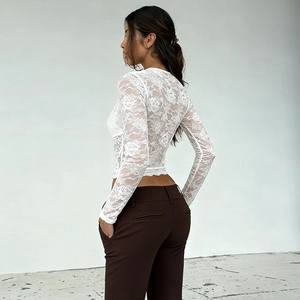 Top bianco in pizzo trasparente con scollo a V, maniche lunghe e vestibilità slim