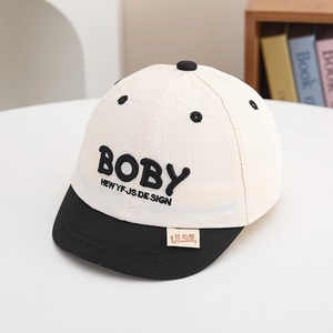Gros plan détaillé d'une casquette bébé avec broderie BOBY et visière noire plate