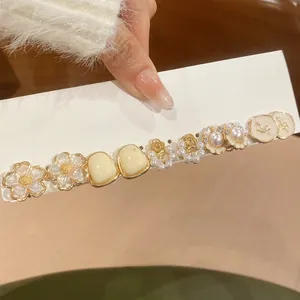 Dettaglio di un set di 5 orecchini con perle e fiori dorati con strass eleganti