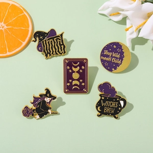 Close-up of five-piece Halloween witch enamel pin set with purple and gold motifs