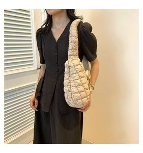Détail d'un sac bandoulière matelassé beige au design nuage en tissu doux et rembourré