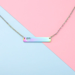 Detail of rainbow stainless steel bar necklace with hollow heart on colorful background