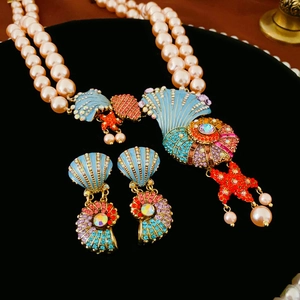 Detailed flat lay of blue enamel shell and starfish earrings with colorful rhinestones
