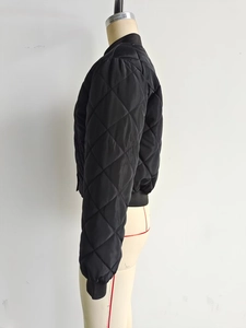 Close-up of diamond quilted pattern and ribbed knit cuffs on a black bomber jacket