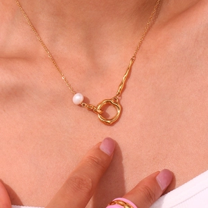 Collier asymétrique en acier doré avec perle blanche et pendentif anneau liquide