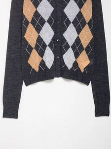 Detail of argyle knit cardigan with dark grey diamond pattern and button-up closure