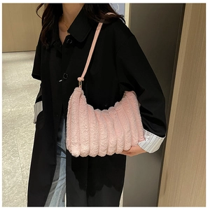 Borsa a spalla in peluche rosa con texture a pieghe su modella con cappotto