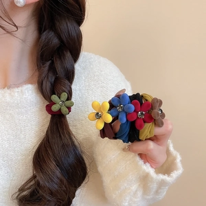 Gros plan sur des chouchous fleurs en velours avec strass en plusieurs couleurs
