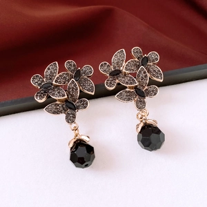 Macro shot of vintage floral earrings with grey rhinestones and black faceted glass drops