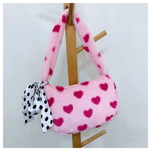 Close-up of pink plush tote bag with heart print and decorative polka dot silk scarf