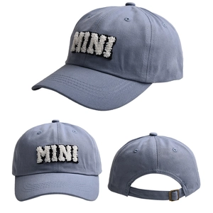 Detail view of light blue cotton baseball cap with white MINI letter embroidery and metal buckle