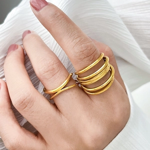 Macro detail of intertwined gold wave rings featuring a layered minimalist stack design