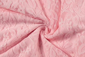 Close-up detail of pink lace fabric with intricate floral embroidery and sheer mesh texture