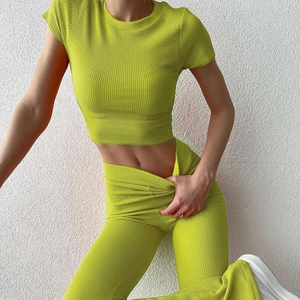 Dettaglio dei pantaloni a vita alta in maglia a coste verde neon per completo casual donna
