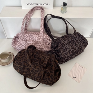 Three leopard print barrel travel bags in pink and brown canvas with wide handles