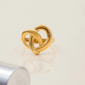Elegant gold heart cross ring in stainless steel with minimalist mirror reflection