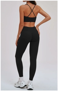 Detail van kruisbandjes op de zwarte sport-bh en legging met hoge taille