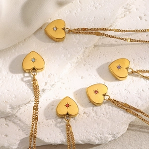Detail of 18K gold plated heart pendants featuring star motifs and colorful zircon gems