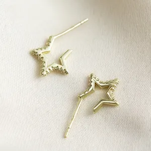 Detalle de pendientes de estrella dorada con cristales y poste de plata de ley S925
