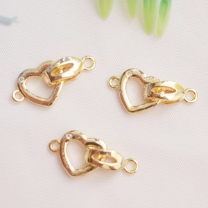 Close-up of 14K gold plated interlocking heart and oval pearl clasps for DIY jewelry