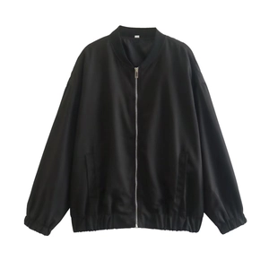 Detail of a black bomber jacket with ribbed collar, cuffs and functional side pockets